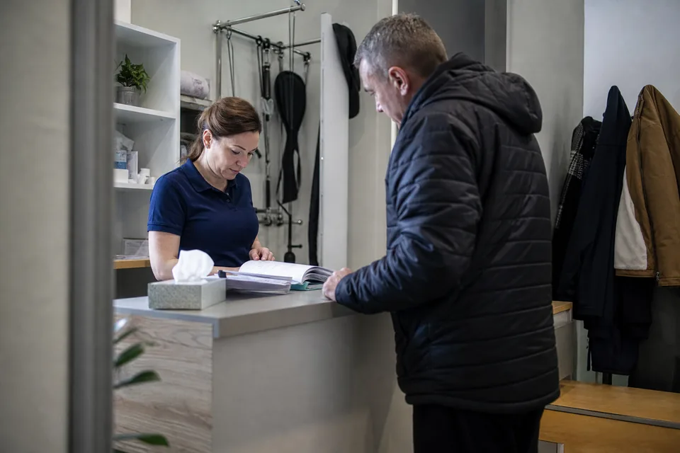 Fizjoterapeutka przyjmuje pacjenta w recepcji
