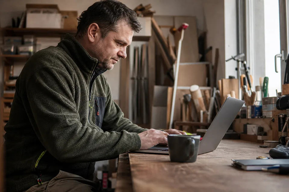 Właściciel firmy wpisuje opis firmy na laptopie